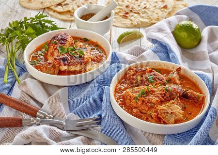 Chicken Stewed In Creamy Spicy Coconut Gravy, Kuku Paka, Served On A White Bowls With Chapati Flatbr