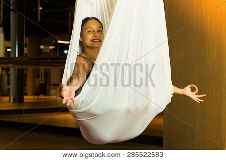 Young Woman Practicing Aerial Yoga In Fitness Studio