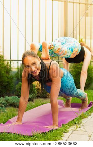 Two Young Women Practicing Acro Yoga Outdoors