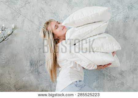 Making Bed. Morning Chores Concept. Woman Holding Pile Of Pillows On Grey Background.