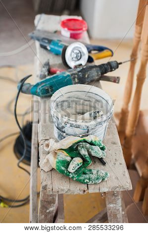 Working Gloves. Do Makeovers. Putty Knife Lying On The Bucket. Tools For Construction And Repair. Se