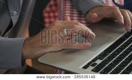 Close Up Details Man Typing On Laptop. Male Hands Entering Data On Keyboard