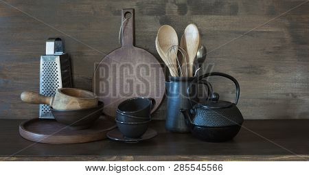 Crockery, Clayware, Dark Utensils And Other Different Stuff On Wooden Tabletop.