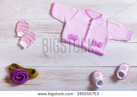 Baby Clothes Pink Knitted Tiny Sweater Cotton Little Mittens Socks On White Wooden Background, Infan