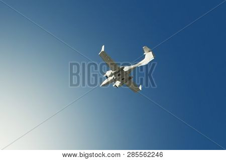 A Small Private White Plane With Screws Flies On The Background  Blue Sky With Clouds