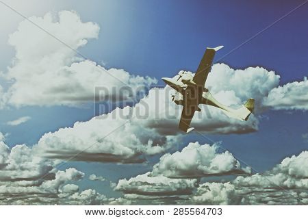 A Small Private White Plane With Screws Flies On The Background Blue Sky With Clouds, Toned