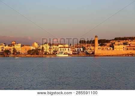 A Beautiful View Of Harbour In Rethymno With Lighthouse And Fortress Fortezza At Sunrise, Crete Isla