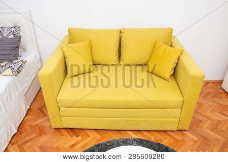 Modern Yellow Two-seat Sofa With Pillows In Hotel Room. Close Up.