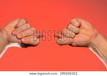 Mans Hand With A Figs Sign Close-up Is Isolated On A Red Background