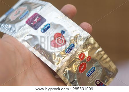 Tyumen, Russia - February 01, 2019: Durex Condom In Hand On Blue Background Close-up. Used To Preven