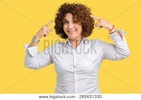 Beautiful middle ager senior businees woman over isolated background Smiling pointing to head with both hands finger, great idea or thought, good memory