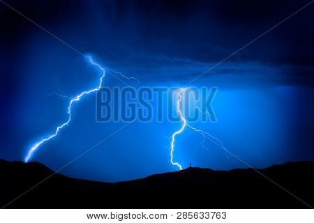 Bright lightning bolts on mountain with radio tower for power and communications