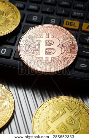 Bitcoins and calculator on a metal table.