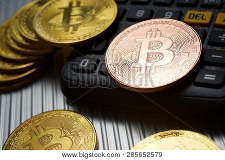 Bitcoins and calculator on a metal table.