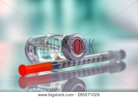 Closeup Of Medicine Vial Or Flu, Measles Vaccine Bottle With Syringe And Needle For Immunization On