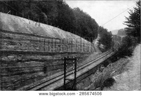 Railway trench having exposed a small section in profile through carboniferous rocks with several small stratifications, vintage engraved illustration. From the Universe and Humanity, 1910.