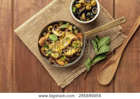 Rustic Mushrooms Saute, Shot From The Top On A Dark Rustic Background With Mint, Olive Pistou, And A
