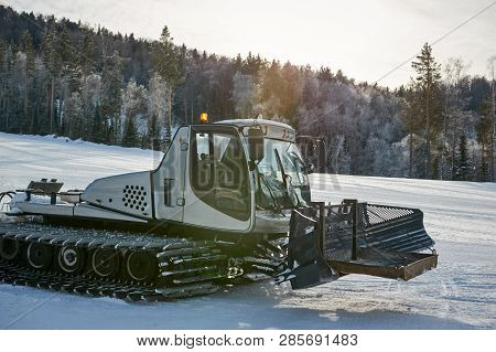 Snowcat With Orange Flasher On The Mountain Frosty Winter Day. Snowcat Is Equal To Snow On A Ski Slo
