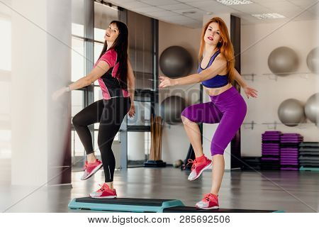 Athletic Mother And Daughter Raising Legs On Step Platforms