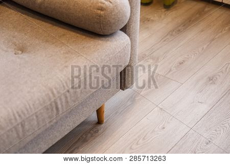 Grey Sofa With Wooden Legs On Lamonate Floor