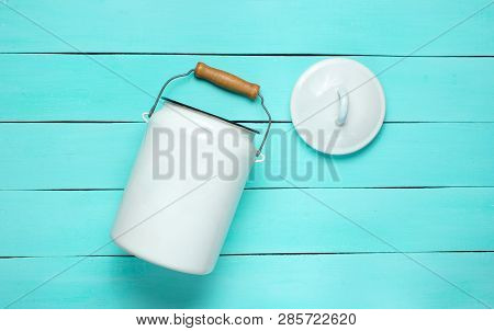Enameled Milk Can On A Blue Wooden Background. Top View