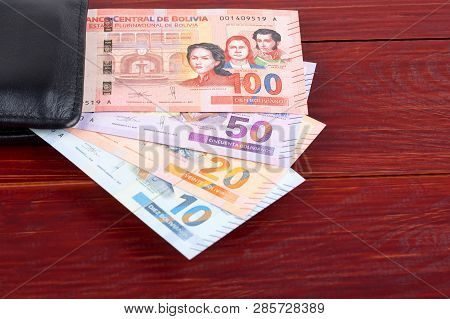 Bolivian Boliviano In The Black Wallet On A Wooden Background