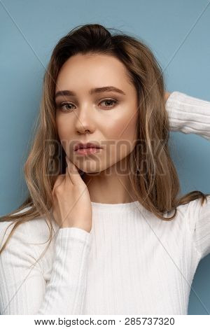 Portrait Of Beautiful Model With Curly Hair On Blue Background And Bright Makeup