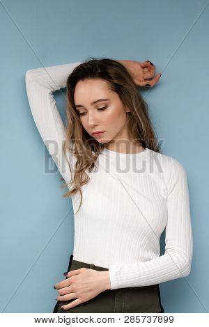 Portrait Of Beautiful Model With Curly Hair On Blue Background And Bright Makeup