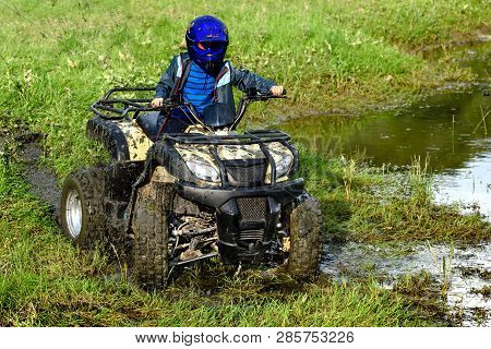 The Boy Is Traveling On An Atv.