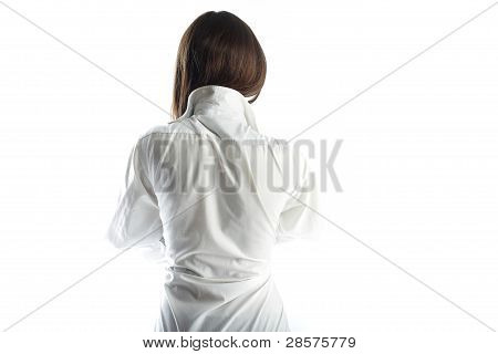 Costas a jovem morena em uma camisa branca