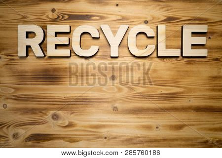 RECYCLE word made with building blocks on wooden board