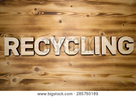 RECYCLING word made with building blocks on wooden board
