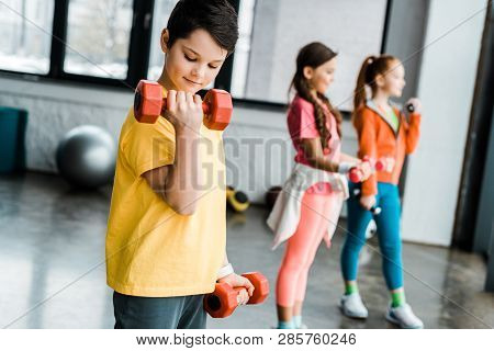 Preteen Kids Training With Dumbbells In Gym