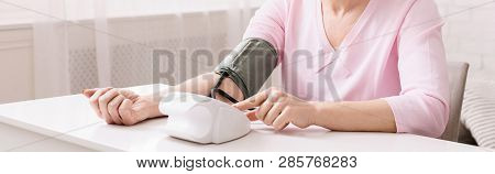 Mature Woman With Hypertension Measuring Blood Pressure Herself, Panorama With Empty Space