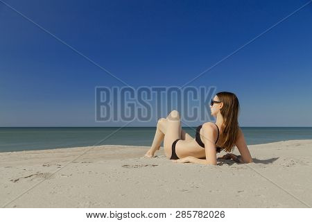 Beautiful Young Woman In Swimsuit At Sand Sea Beach Looking At Sea