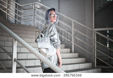 Outdoor Portrait Of An Extraordinary Student Girl With Ashen Blue Hair Dressed In A Cloak With A Sil