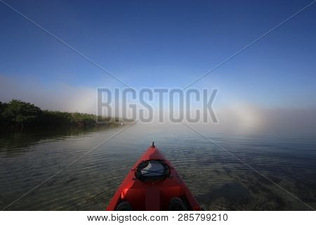 Key Biscayne, Florida 01-16-2016 Red Kayak Heading Toward A Bright Fogbow Over Bear Cut Off Key Bisc