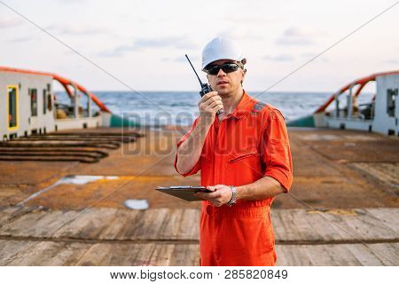 Deck Officer On Deck Of Offshore Vessel Holds Vhf Walkie-talkie Radio