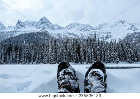 A Closeup View Of A Person And Their Pair Of Snowshoes In Fernie, British Columbia, Canada.  The Maj