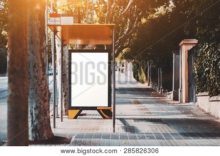 Urban Bus Stop Near The Road With Poster Placeholder Inside; Vertical Blank Advertising Banner Mock-
