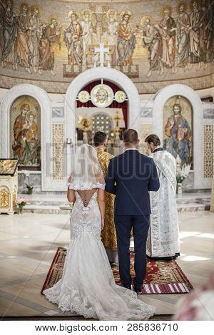 The Bride And The Groom Are Standing In The Chapel In Front Of The Two Chaplains.