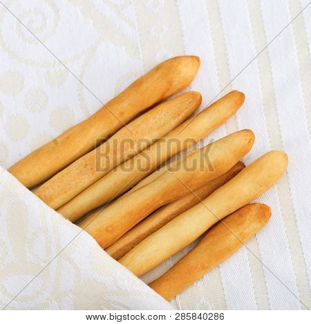 Local Italian Bread, Homemade Breadsticks Grissini On Cloth. Baked Italian Grissini Close-up. Tradit