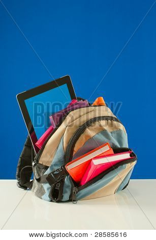 Sac à dos avec livres colorés et Tablet Pc sur le fond bleu