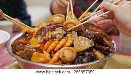 Eating Poon Choi together at home, Chinese cuisine for lunar new year