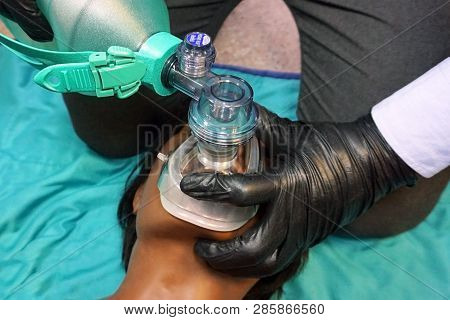 Medical Stuff In Black Gloves Performing Artificial Ventilation Using Bag Valve Mask (ambu Bag) On A