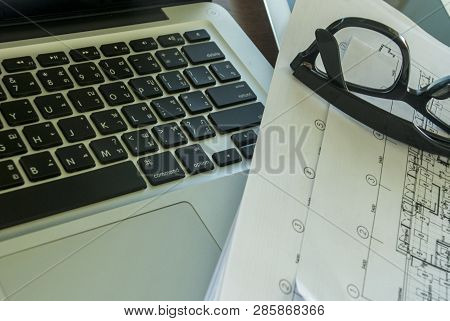 Work Area With Laptops And Communication Devices Including Work Papers And Glasses In A Relaxing Are