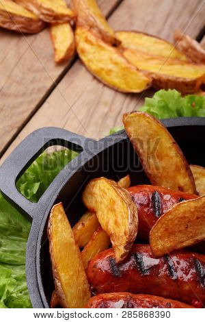 Grilled Sausages.baked Potatoes .on Wooden Taable.copy Space.