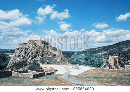 Famous Castle Devin Near Bratislava, Slovak Republic, Central Europe. Cloudy Sky And Surrounding Lan