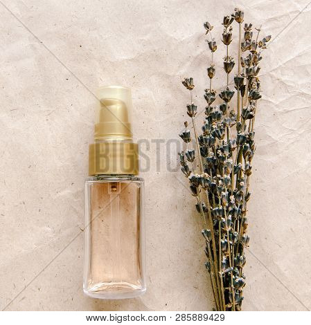 Facial oil Still life Facial oil Still life Skincare oil and the lavender bouquet are lying on a craft paper background Photo template in a flat lay