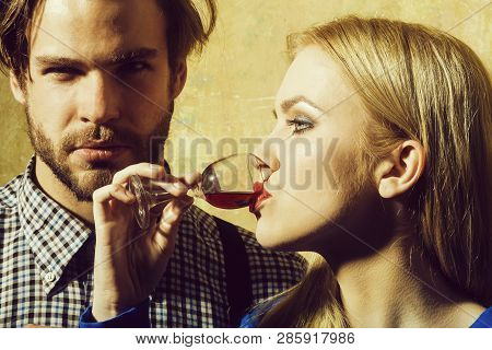 Girlfriend Drinking Red Liqueur In Glass And Boyfriend. Woman Or Girl With Blond Hair And Handsome M